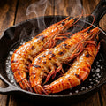 Giant tiger prawns searing in a cast iron pan